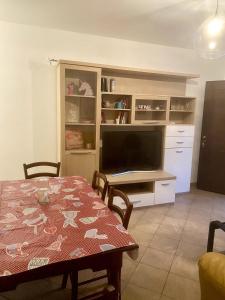a dining room with a table and a television at Casa Vacanze - Villa Claudia in Leporano Marina