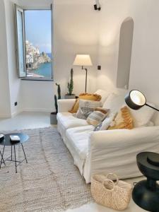 a white living room with a couch and a table at Casa Tusci Amalfi Sea View Duomo Ferry to Positano in Amalfi