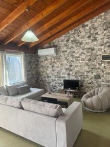 a living room with a couch and a stone wall at Country House in Kanakádes