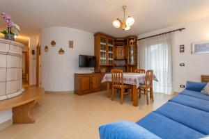 a living room with a table and a blue couch at Casa Erica in Falcade