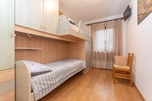 a small bedroom with a bed and a chair at Casa Erica in Falcade