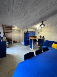 a living room with a blue bed and a kitchen at House Beskyd in Skole