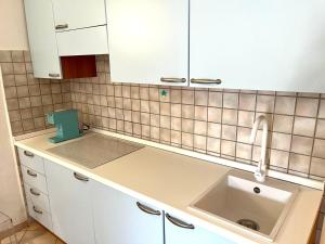 a kitchen with a sink and white cabinets at Elena's apartment in Cannigione +19 photos