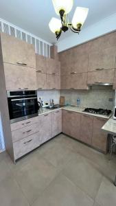 a large kitchen with wooden cabinets and a ceiling at Apartment Katya in Batumi