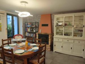 una sala da pranzo con tavolo e camino di Gite du bon accueil maison de vacances a Porcaro