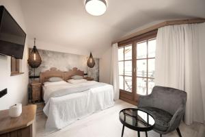 a bedroom with a bed and a chair and a television at Berg-Leben in Grossarl