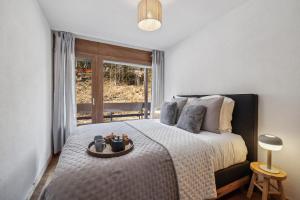 une chambre avec un grand lit et une fenêtre dans l'établissement Imperial by Mrs Miggins, à Crans-Montana 2 autres photos