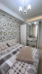 a bedroom with a large bed and a large mirror at Apartment Katya in Batumi