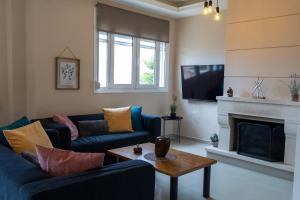 een woonkamer met twee blauwe banken en een open haard bij Dream Villa in Kokkíni Khánion