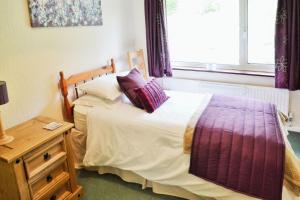 Un dormitorio con una cama y una mesa y una ventana. en Baltija, en Ventnor