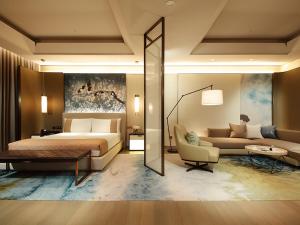 a bedroom with a king sized bed and a couch at Grand Mayfull Taipei in Taipei