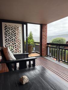 a screened porch with a bench and a table at Dolphin Dunes Guesthouse in Wilderness