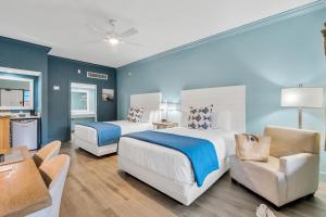 a bedroom with two beds and a living room at Beachside Inn in Destin