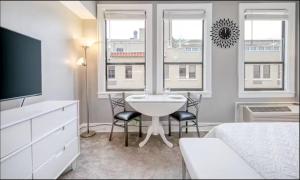 a bedroom with a bed and a sink and two windows at Palm Beach Modern Condo-Beach Attractions Nearby in Palm Beach