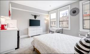 a white bedroom with a bed and a desk and a sink at Palm Beach Modern Condo-Beach Attractions Nearby in Palm Beach +20 photos