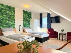 a hotel room with two beds and a table at Landhaus am Damme in Garbsen