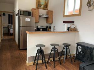 a kitchen with a counter and four bar stools at Native Spirit Cabin at Base Camp in Dumont