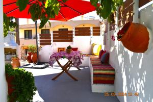 a patio with a table and a red umbrella at Mannas House 2 in Émbonas