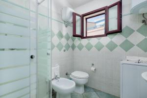 ein Badezimmer mit Toilette, Waschbecken und Spiegel in der Unterkunft Casa Del Marinaio in Cala Gonone