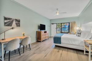 a bedroom with a bed and a desk and a television at Beachside Inn in Destin
