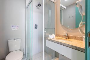 a bathroom with a toilet and a sink and a mirror at Studio - Setin Downtown Estação Luz - Sou House in São Paulo
