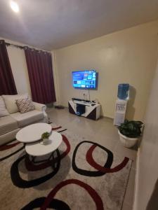 a living room with a couch and a table and a tv at La Ribera Homes in Bomet +9 photos