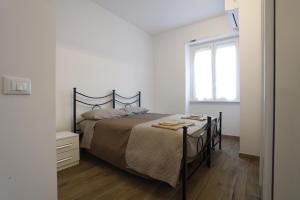 a white bedroom with a bed and a window at Marina House - Iulm Navigli San Paolo in Milan