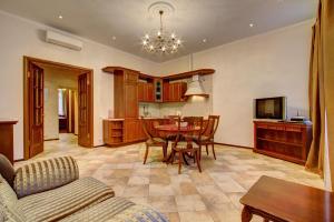 a living room with a table and a kitchen at STN Apartments by Moskovskiy Railway Station in Saint Petersburg