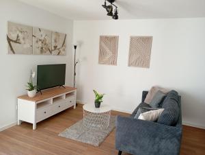 a living room with a couch and a tv at Engmels Ferienwohnung in Volkertshausen