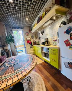 a kitchen with yellow cabinets and a white refrigerator at Green house, cosy garden Paris in Alfortville