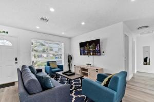 a living room with two blue chairs and a table at Cozy Hollywood Private Pool Retreat - Ping pong in Hollywood