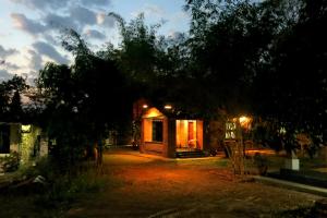 a small cabin at night with lights on at Clayfingers Art Cottage in Trichūr