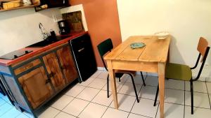a small kitchen with a wooden table and a counter at LA STATION 710 Gîte insolite entre Sioule et Sancy in Les Ancizes-Comps +14 photos