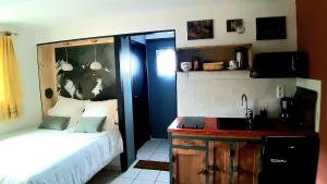 a small bedroom with a bed and a sink at LA STATION 710 Gîte insolite entre Sioule et Sancy in Les Ancizes-Comps
