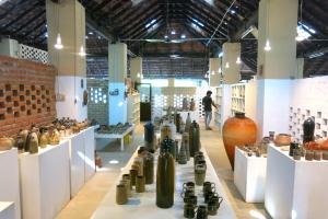 a room filled with lots of different types of vases at Clayfingers Art Cottage in Trichūr