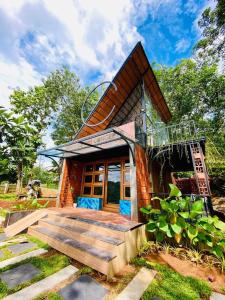 a small house with a wooden staircase leading to it at NATURESGrandeur#ModernCabinTropical HABITAT#Kerala in Pathanāmthitta