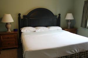 une chambre avec un grand lit avec des draps blancs et deux lampes dans l'établissement Wild Eagle Lodge, 1 Bedroom Condo - 103, à Eagle River 30 autres photos