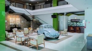 a room with an old car and tables and chairs at Holiday Inn Queretaro Zona Krystal by IHG in Querétaro