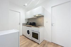 a kitchen with a washer and dryer next to a door at Bright 1-bedroom apartment in Cuxac-dʼAude