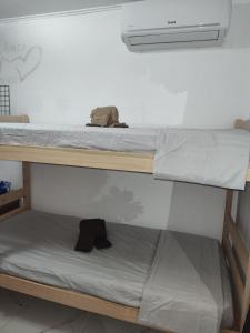 two bunk beds in a room with a hat on them at Hostel da Rô, Praia Grande in Praia Grande