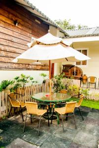 un tavolo e sedie con ombrellone su un patio di Song Youf Hostel a Zhongpu