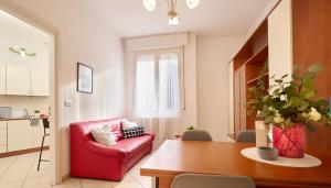 a living room with a red couch and a table at HomeSerra 2 in Bologna