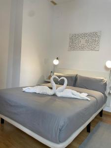 - un lit avec 2 cygnes en serviettes dans l'établissement Ático centro "El diván azul", à Malaga