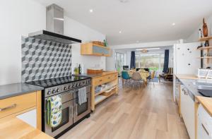 a kitchen with a stove top oven next to a table at Sea Breeze in Brading