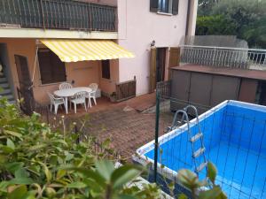 a patio with a table and chairs and a pool at Casa PO LAZISE in Lazise