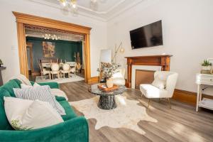 a living room with a green couch and a fireplace at Elegant Escape, Modern Luxe in Historic Suite in Saint John +10 photos