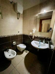 un bagno con lavandino, WC e specchio di Bed & Breakfast De Bono a Napoli