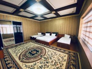 a bedroom with two beds and a large rug at Samandar in Bukhara