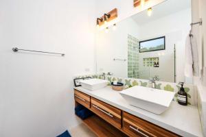 a bathroom with two sinks and a mirror at Villa Serenity 4 bedroom 1 min walk to the beach in Santa Cruz