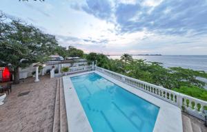 an outdoor swimming pool with a view of the ocean at Casa de playa Vistamare in Santa Marta